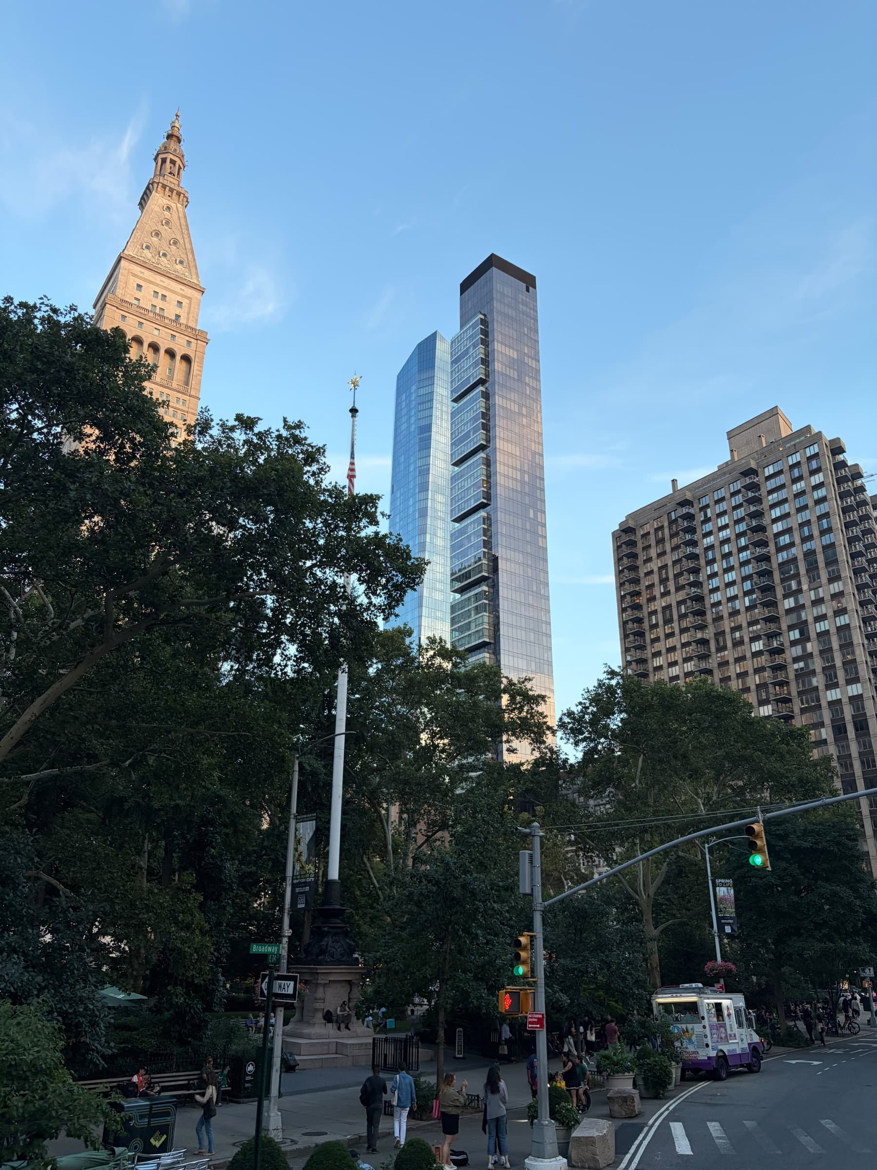 Madison Square Park with glass towers and the Metropolitan Life tower above the trees